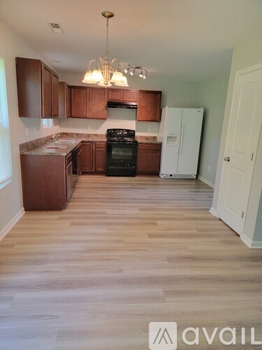 A kitchen with wooden floors and cabinets.