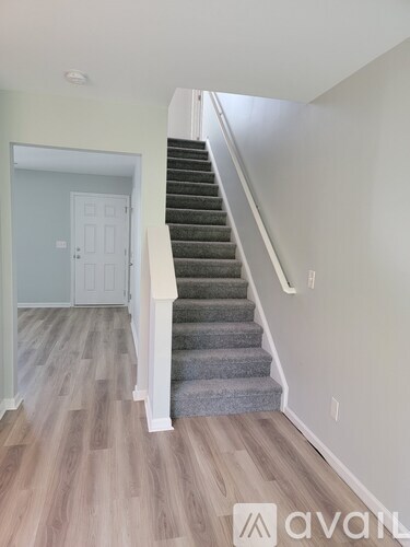 A staircase with a grey carpeted runner and wooden steps.