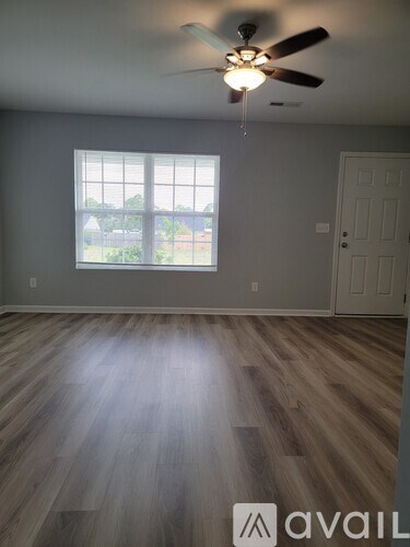 A room with a ceiling fan and a window.