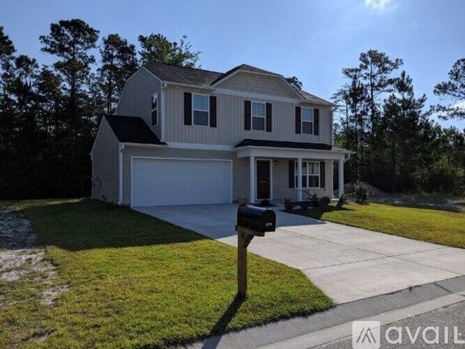 A house with a garage and a mailbox in front of it.