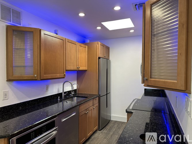 A kitchen with wooden cabinets and black countertops.