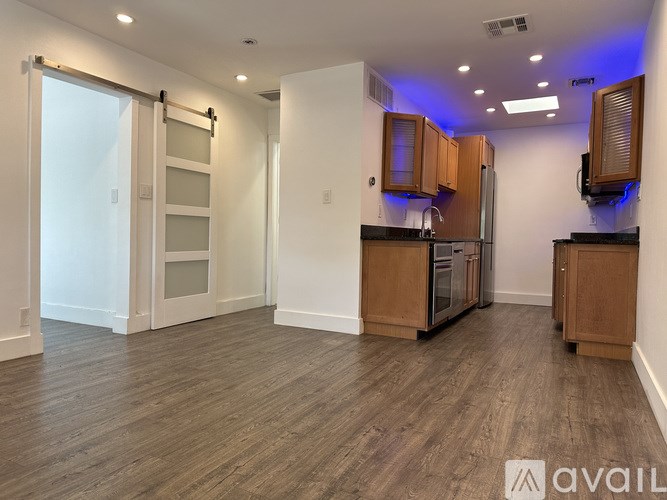 A kitchen area with wooden cabinets and a refrigerator.
