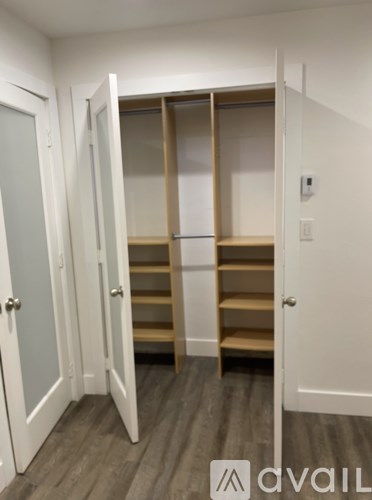 A room with a white door and a shelving unit.