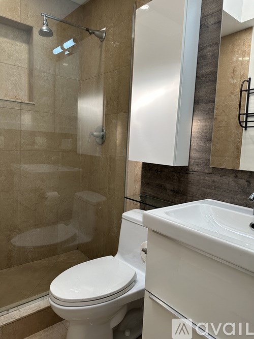 A white toilet in a bathroom with a glass shower door.
