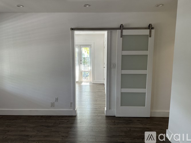 A room with a sliding door leading to a balcony.