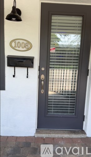 A black door with a glass window and a mailbox on the wall.
