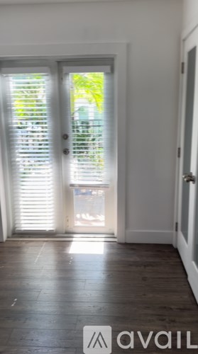 A room with a sliding door and wooden floor.