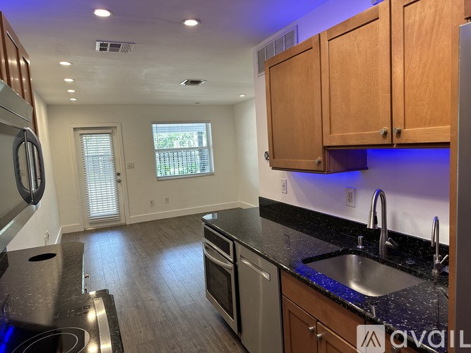 A kitchen with wooden cabinets and a black countertop.