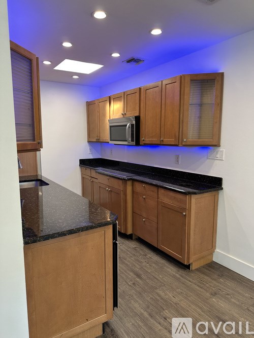 A kitchen with wooden cabinets and a black countertop.