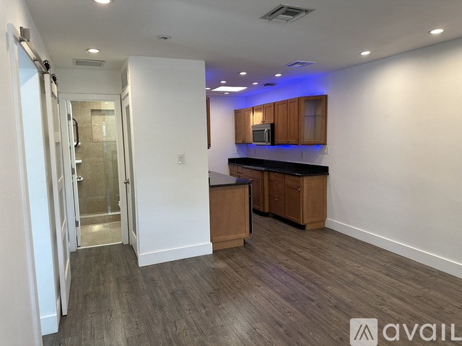 A spacious kitchen area with wooden cabinets and a microwave.