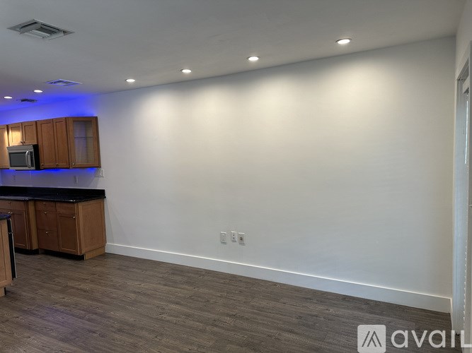 A kitchen with wooden cabinets and a black countertop.