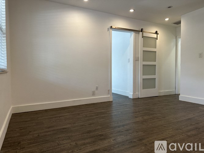 A room with wooden flooring and a sliding door.