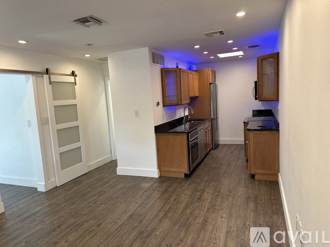 A kitchen with wooden cabinets and a black countertop.