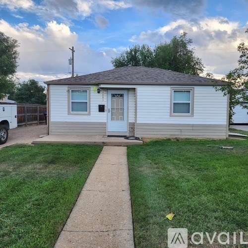A small house with a white door and a grey roof.