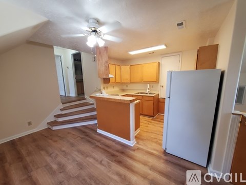 A kitchen with wooden cabinets and a white refrigerator.
