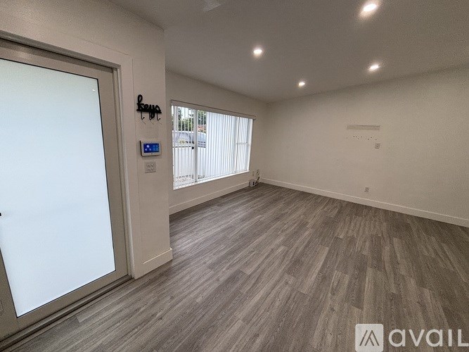 A room with wooden flooring and a sliding glass door.