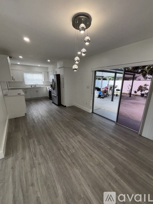 A spacious kitchen with wooden flooring and a modern design.