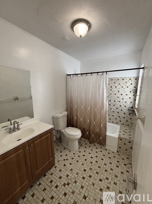 A bathroom with a toilet, sink, and shower.
