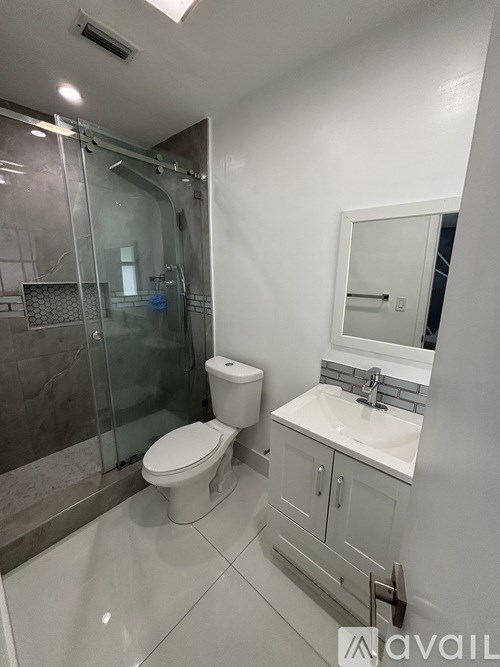 A bathroom with a toilet, sink, and shower.
