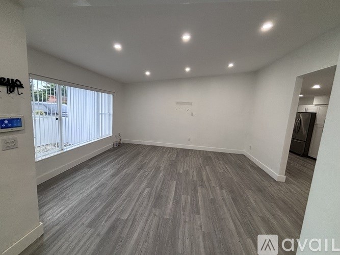 A spacious room with grey flooring and white walls.