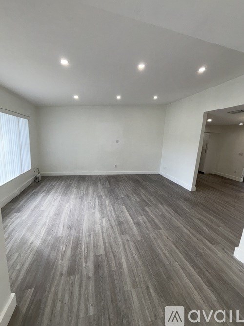 A room with wooden flooring and white walls.