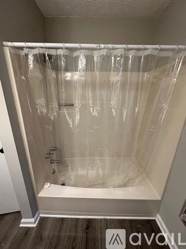 A shower with a plastic curtain over it.