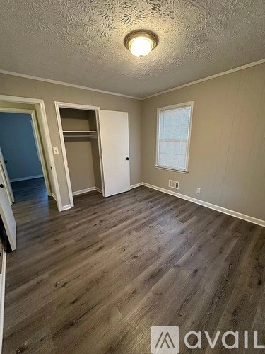 A room with wooden flooring and a window.