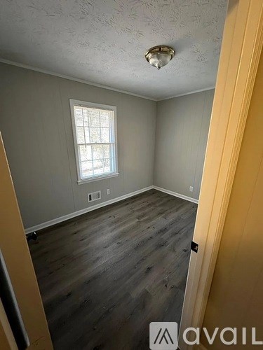 A room with a window and wooden floors.
