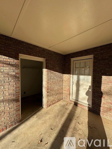 A room with a brick wall and a window.