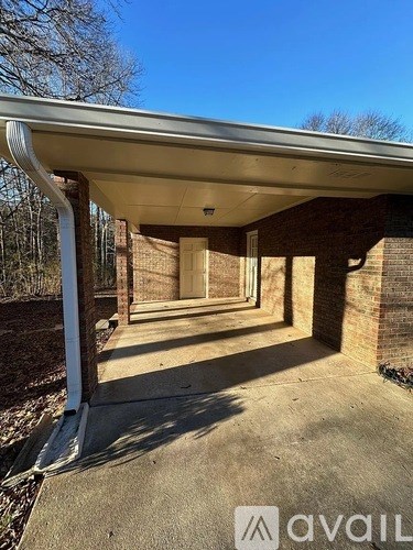 A covered walkway with a brick wall on one side and a metal pole on the other.
