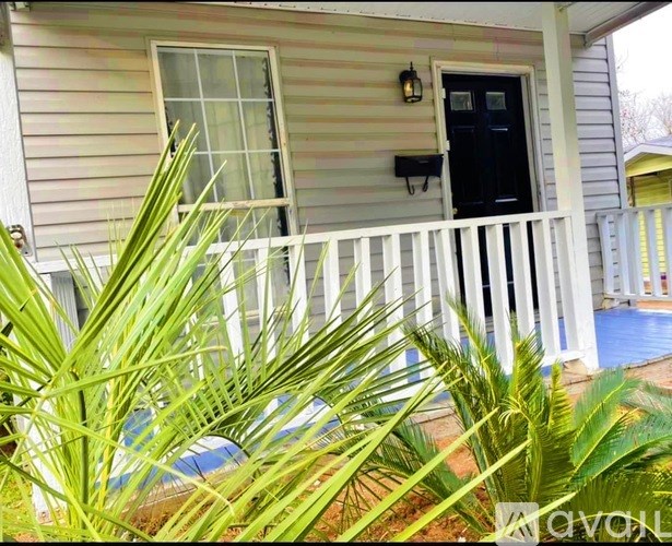 A house with a black door and a white fence.