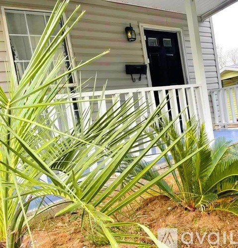 A house with a black door and a white fence.