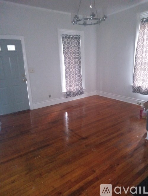 A room with wooden floors and a chandelier.