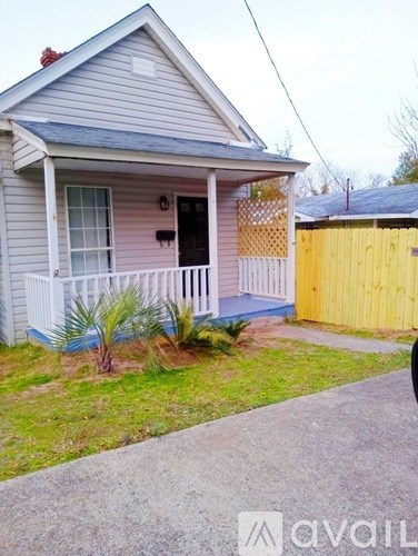 A house with a blue roof and a yellow fence.