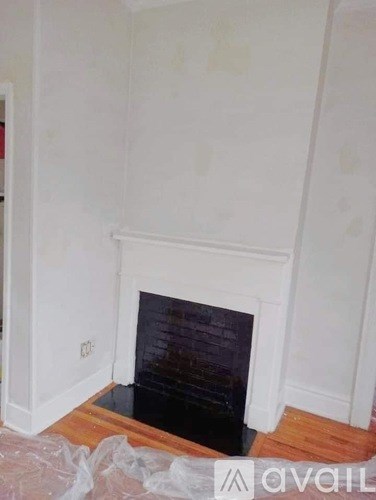 A white fireplace in a room under renovation.
