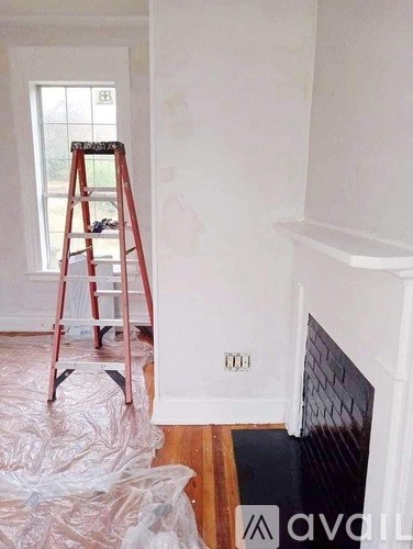 A room with a ladder and a fireplace under construction.