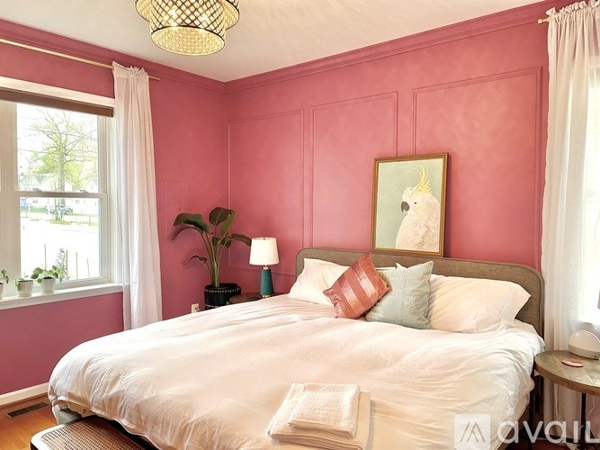 A bedroom with a bed, nightstand, and window.