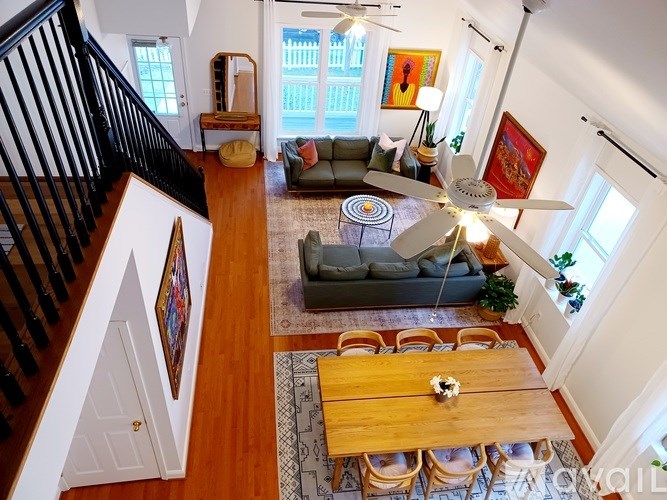 A living room with a couch, a coffee table, and a ceiling fan.