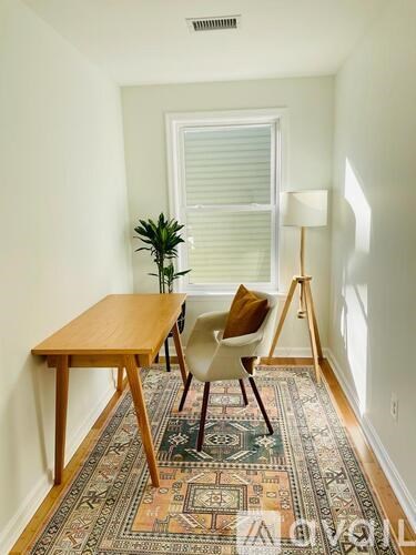 A room with a table, chairs and a rug.
