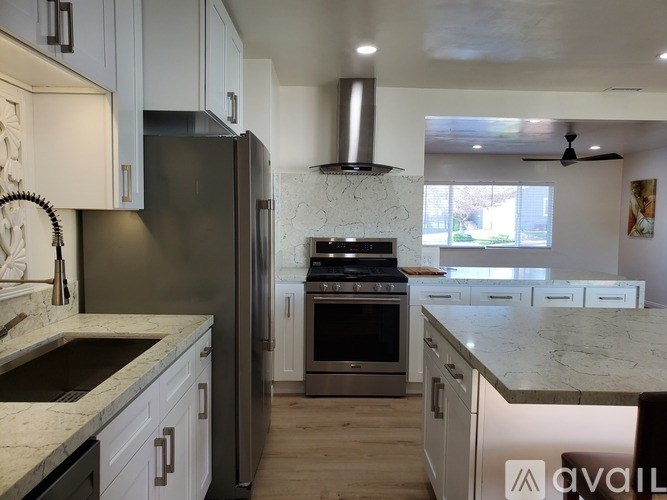 A modern kitchen with a refrigerator, stove, and oven.
