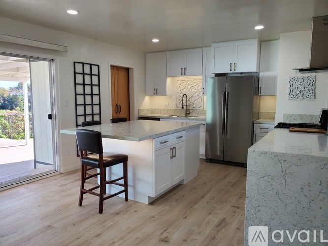 A kitchen with a bar stool in front of it.