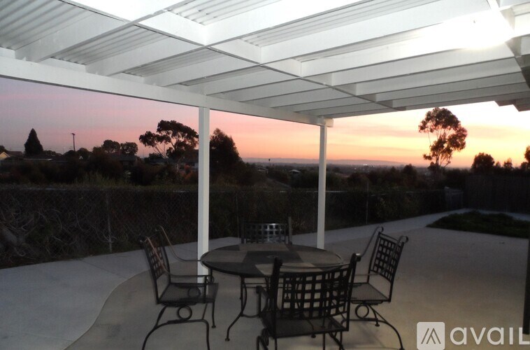 A patio with a table and chairs is set up for an evening outside.