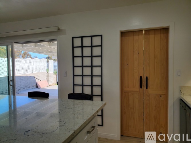 A room with a ceiling fan and a door with a mirror on it.