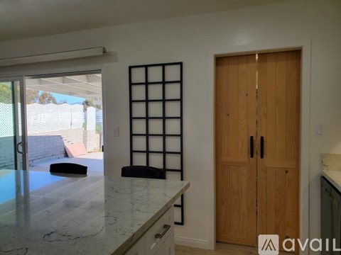 A room with a ceiling fan and a door with a mirror on it.