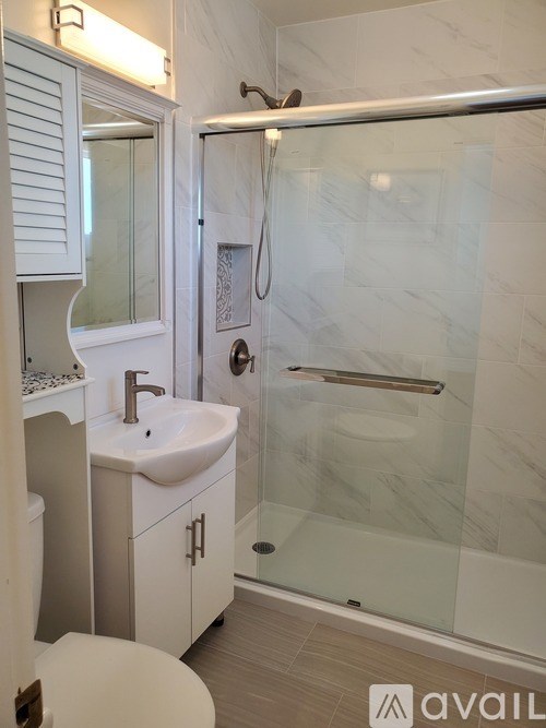 A bathroom with a white sink and a walk-in shower.