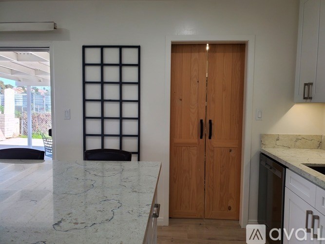 A kitchen with a marble countertop and wooden cabinets.