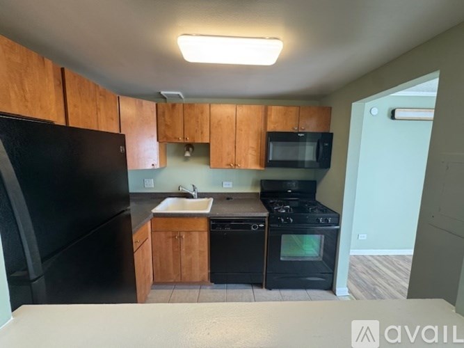 A kitchen with wooden cabinets and black appliances.