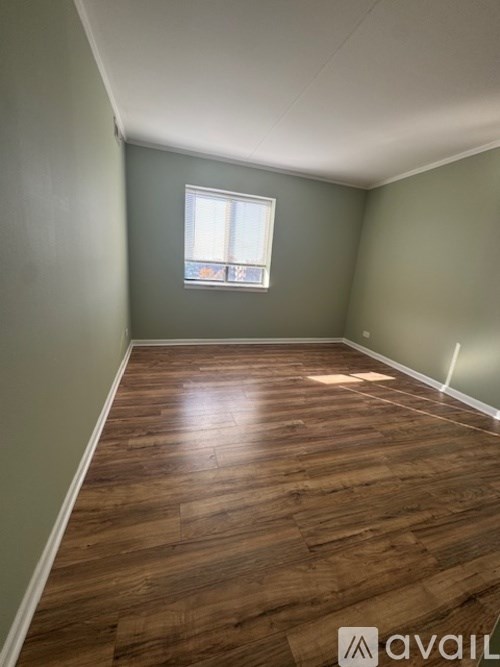 A room with wooden flooring and a window.