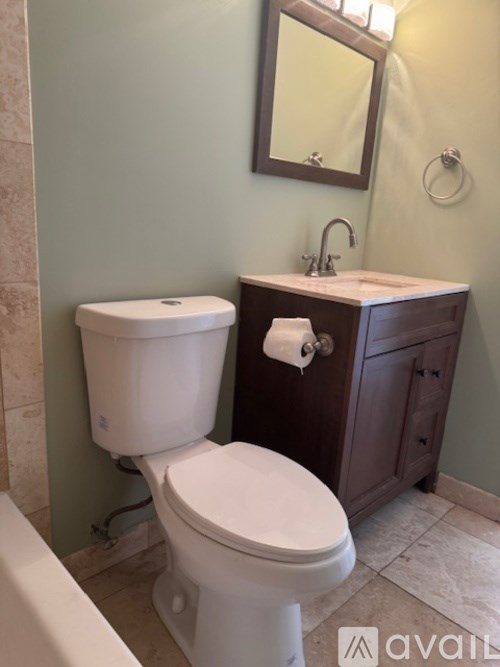 A white toilet sits next to a sink in a bathroom.