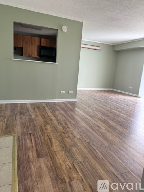 A room with wooden flooring and a television in a cabinet.